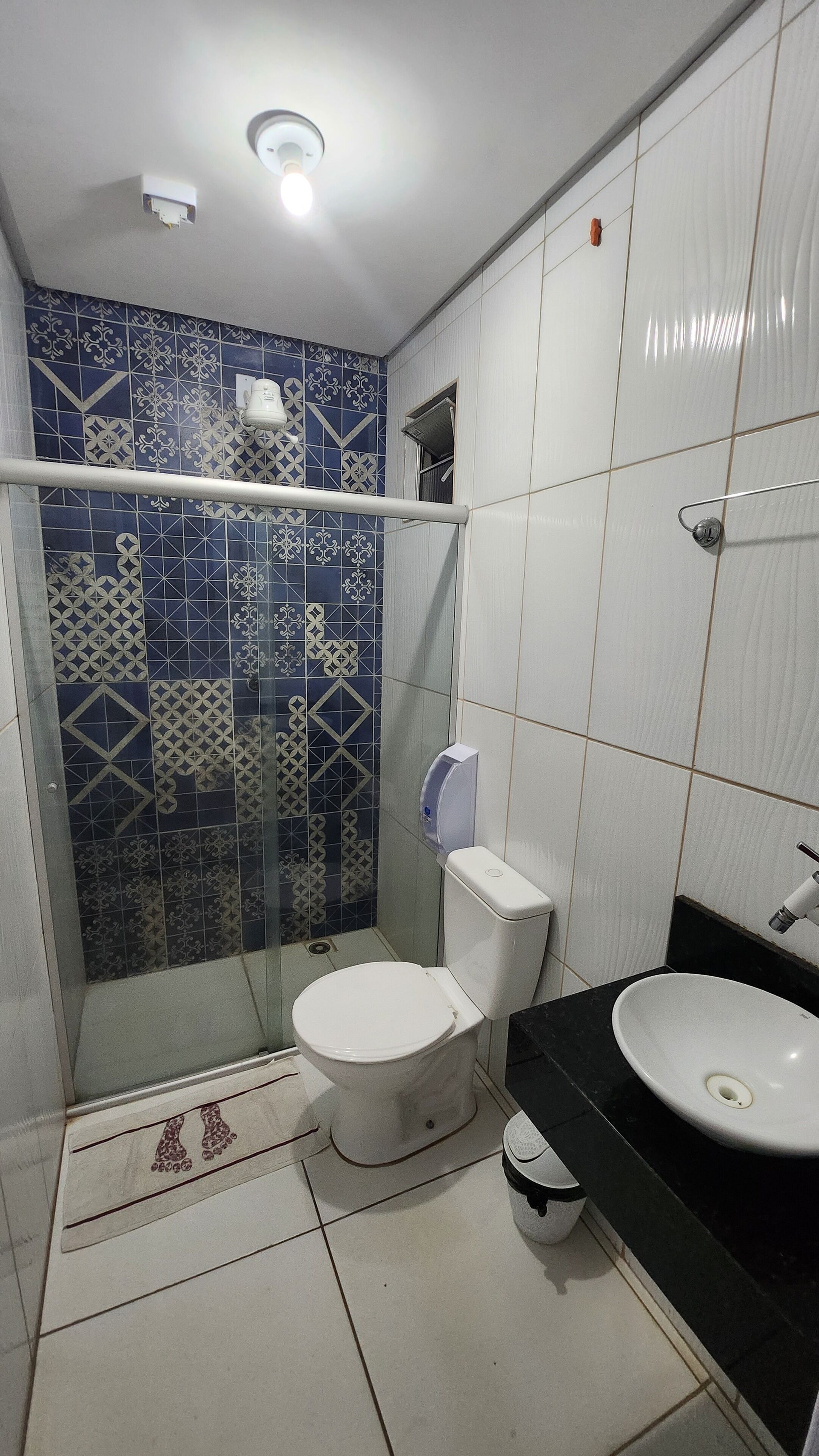 A bathroom with a shower, toilet, and sink.