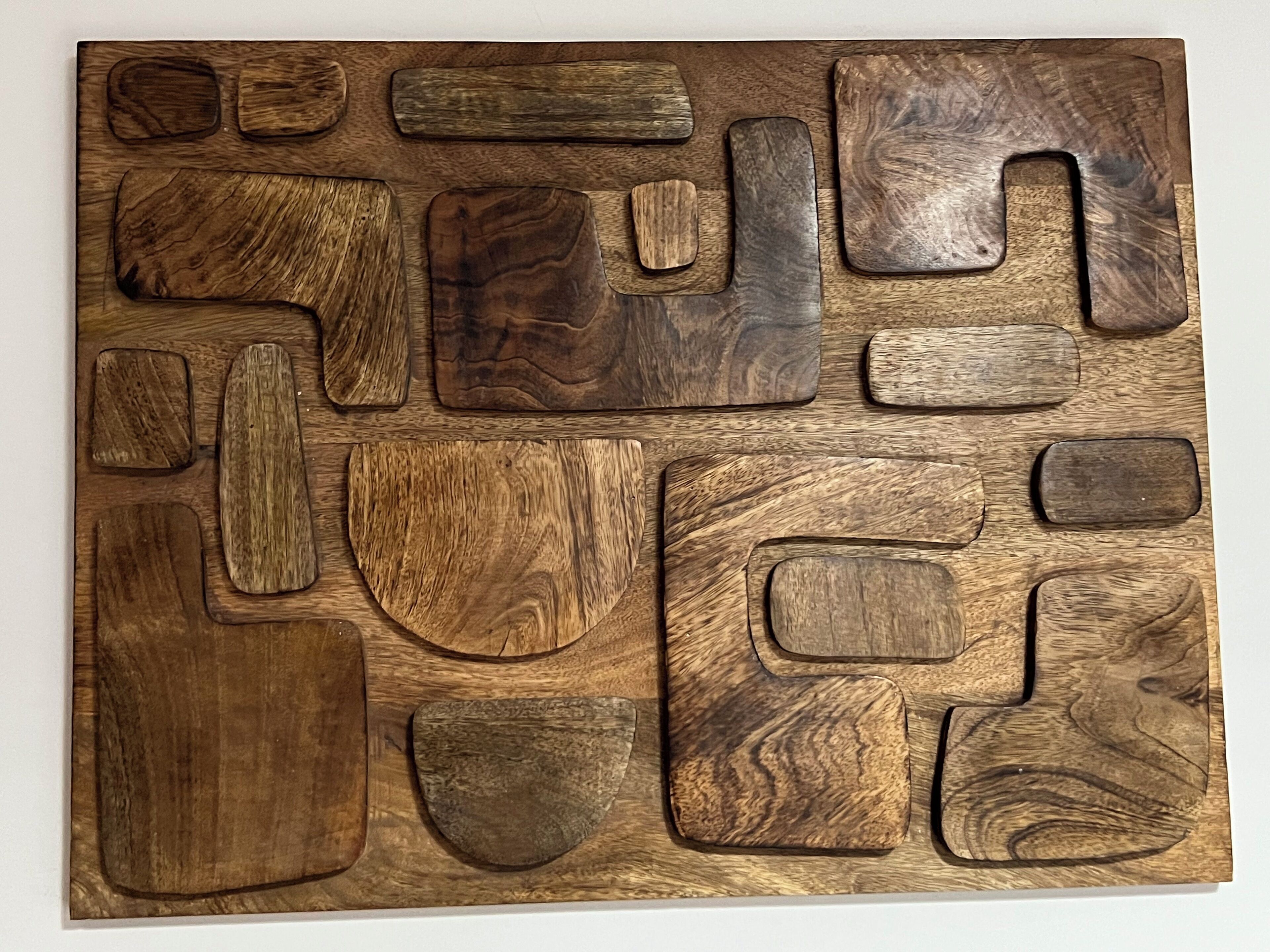 Un pannello di legno con diverse forme e texture geometriche.