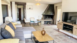 A living room with a sofa, chairs, a coffee table, a fireplace, and a television. - Vacation home Zita by Interhome (Saint Aygulf)