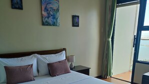 A bed with white linens, two pillows, a nightstand with a lamp, and a window with curtains. - 1-bedroom condo with a magnificent Manila Bay sunset view. (Manila)
