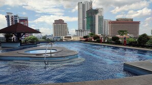 A swimming pool with a circular design, surrounded by a concrete deck. - 1-bedroom condo with a magnificent Manila Bay sunset view. (Manila)