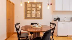 A dining area with a round wooden table, black chairs, and a tray with cups and a teapot.