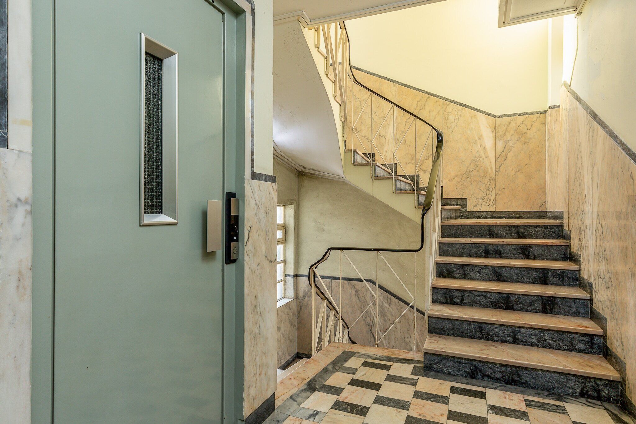A staircase with marble steps and a checkered floor pattern.