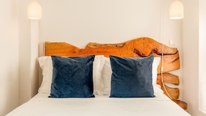 A bed with a wooden headboard, two pillows, and a white mattress. - Well-equipped apartment in Oporto (Oporto)