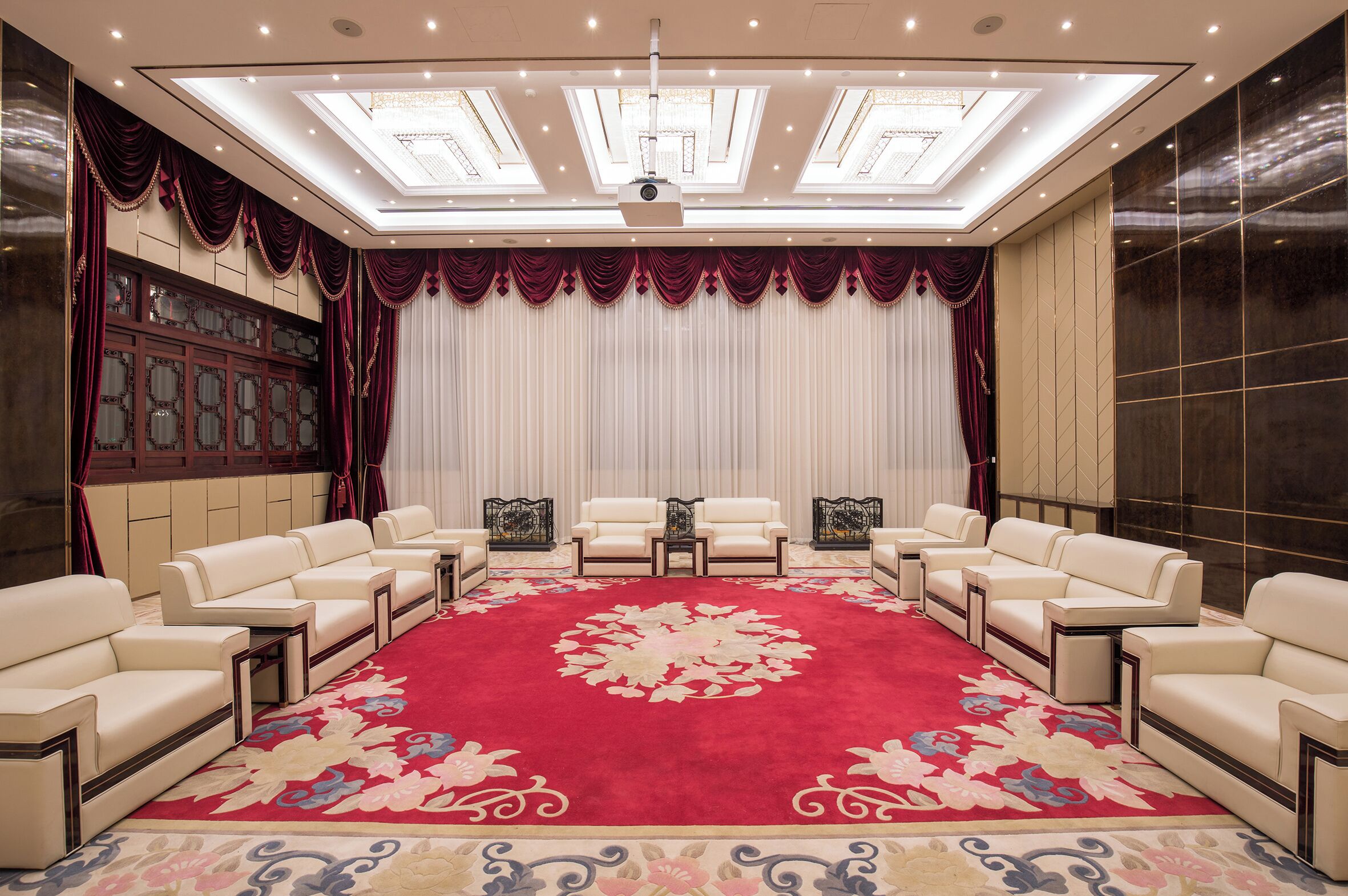 A conference room with a red carpet, white curtains, and a ceiling with skylights.