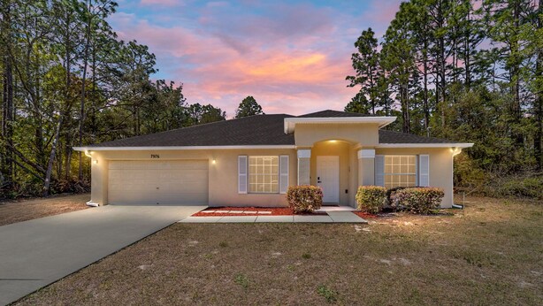 A single-story house with a garage, a front porch, and a driveway.