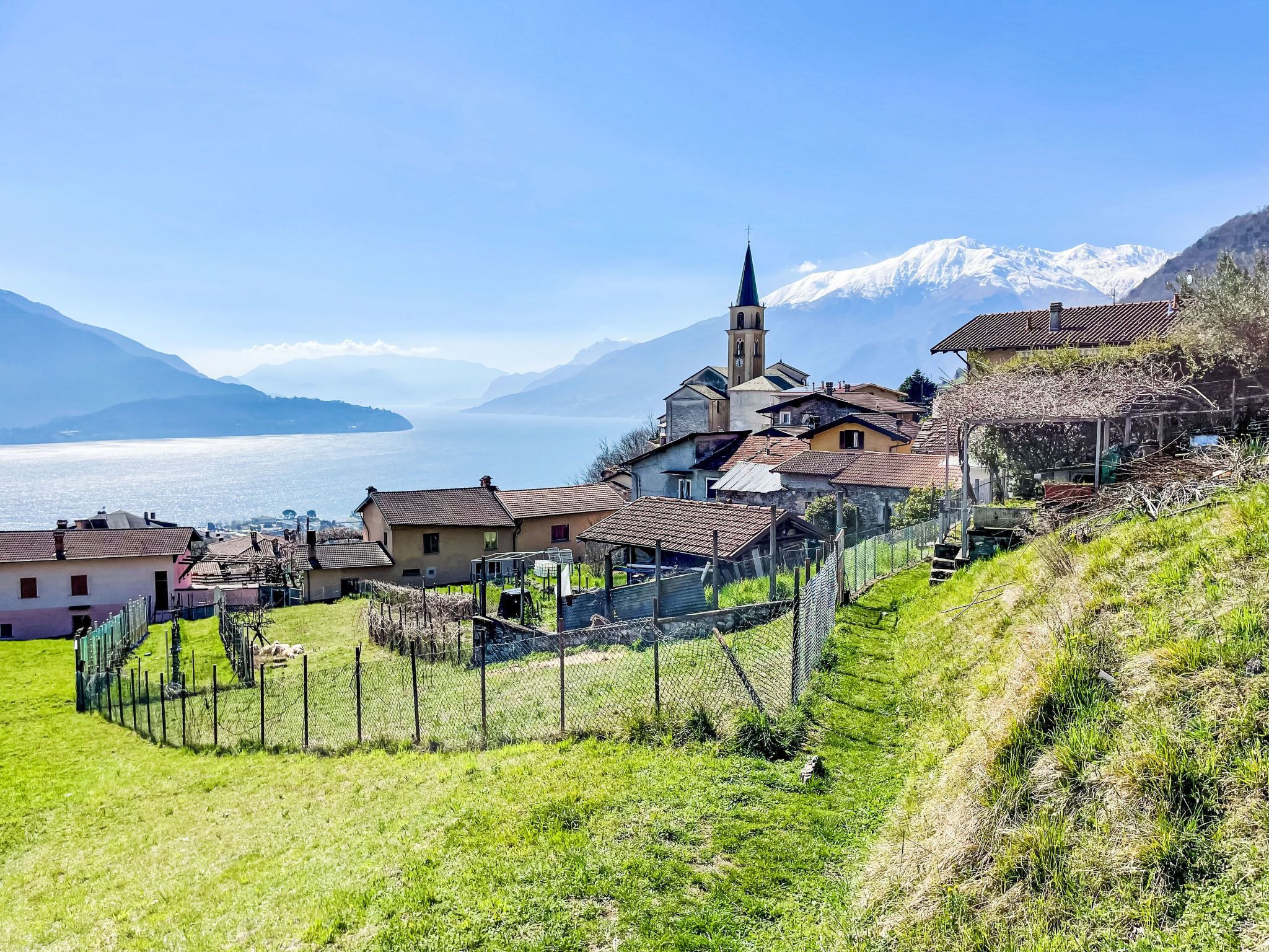Un village à l’architecture traditionnelle, une église dotée d’un clocher et, au loin, un lac.