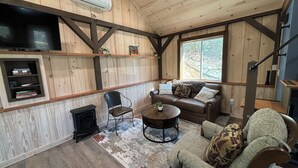 Una sala de estar acogedora con chimenea, un sofá, un sillón y una mesa de centro.