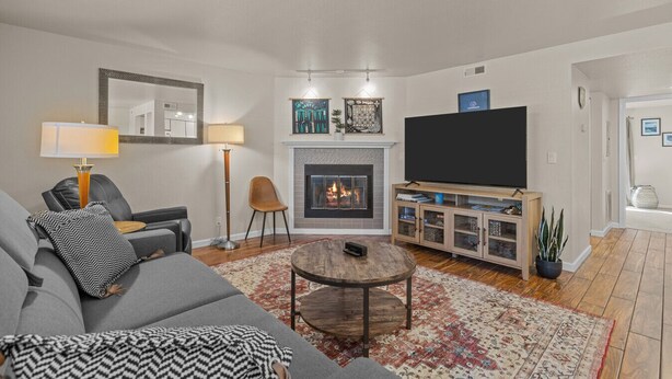 A living room with a fireplace, a sofa, a coffee table, a TV, and a bookshelf. - Boise's Lost Treasure (Boise)