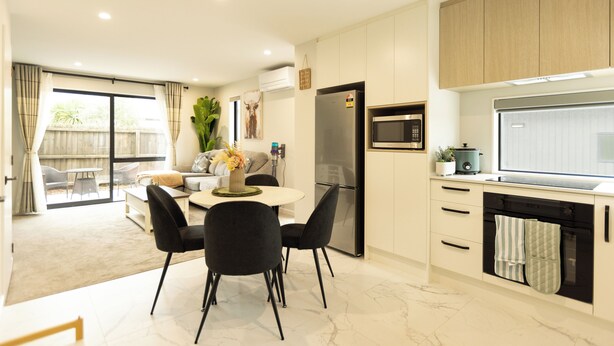 A modern kitchen with a built-in oven, microwave, and refrigerator. There is a dining area with a round table and chairs. - Brand New 3BR Home with Parking in Christchurch (Tristate)