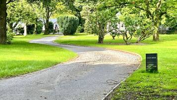 Une route sinueuse traversant un parc, avec un panneau indiquant « Conch House » et « Wild Stream Terrace ».