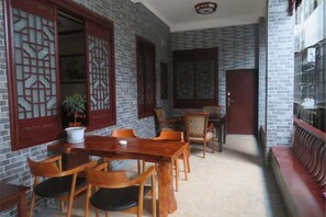 A room with a brick wall, wooden furniture, and a potted plant.