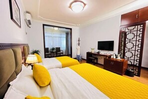 A hotel room with two beds, a desk, a TV, and a wardrobe.