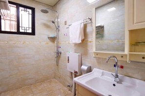 A bathroom with a shower, a sink, and a mirror.