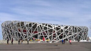Een modern stadion met een opvallend geometrisch ontwerp, met een ruime open ruimte ervoor.