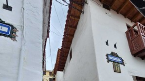Μια σκάλα που οδηγεί προς ένα κτίριο με βάση από πέτρα και λευκή πρόσοψη.
