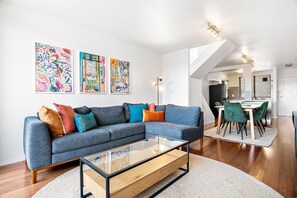 Relax in this stylish living room with a sofa, coffee table, and dining area.