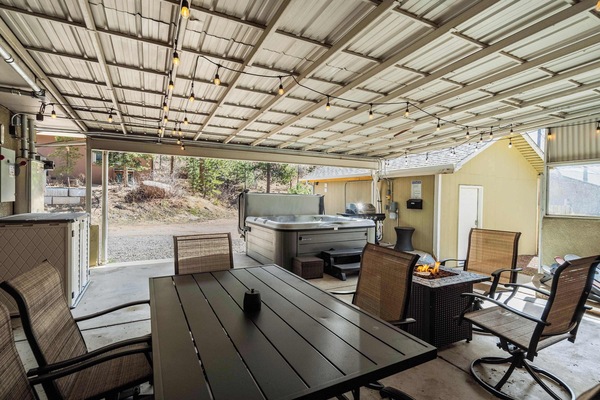 Welcome to Mountain Villa! This spacious covered patio invites you to unwind with a hot tub, cozy seating, and a dining area—perfect for enjoying the fresh mountain air in comfort.