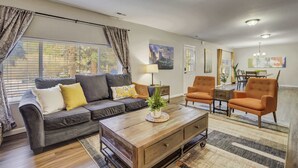 A living room with a sofa, armchairs, a coffee table, and a dining area with a table and chairs. - Mountain Villa! Scenic Getaway with Hot Tub (Cascade-Chipita Park)