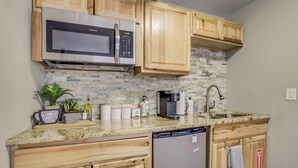A kitchen with wooden cabinets, a stainless steel microwave, a coffee maker, and a dishwasher. - Mountain Studio! Cozy Escape with Stunning Views (Cascade-Chipita Park)