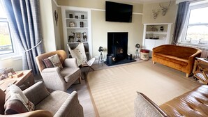 A living room with a fireplace, a television, and a sofa.