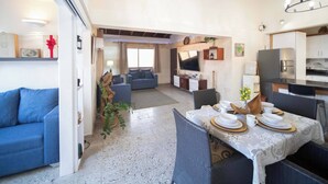 Un espace de vie moderne comprenant un coin repas, une cuisine et un coin salon confortable.