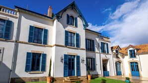 A white building with blue shutters and a tiled roof. - Solstice Beaune - Hotel et Terroir (Beaune)
