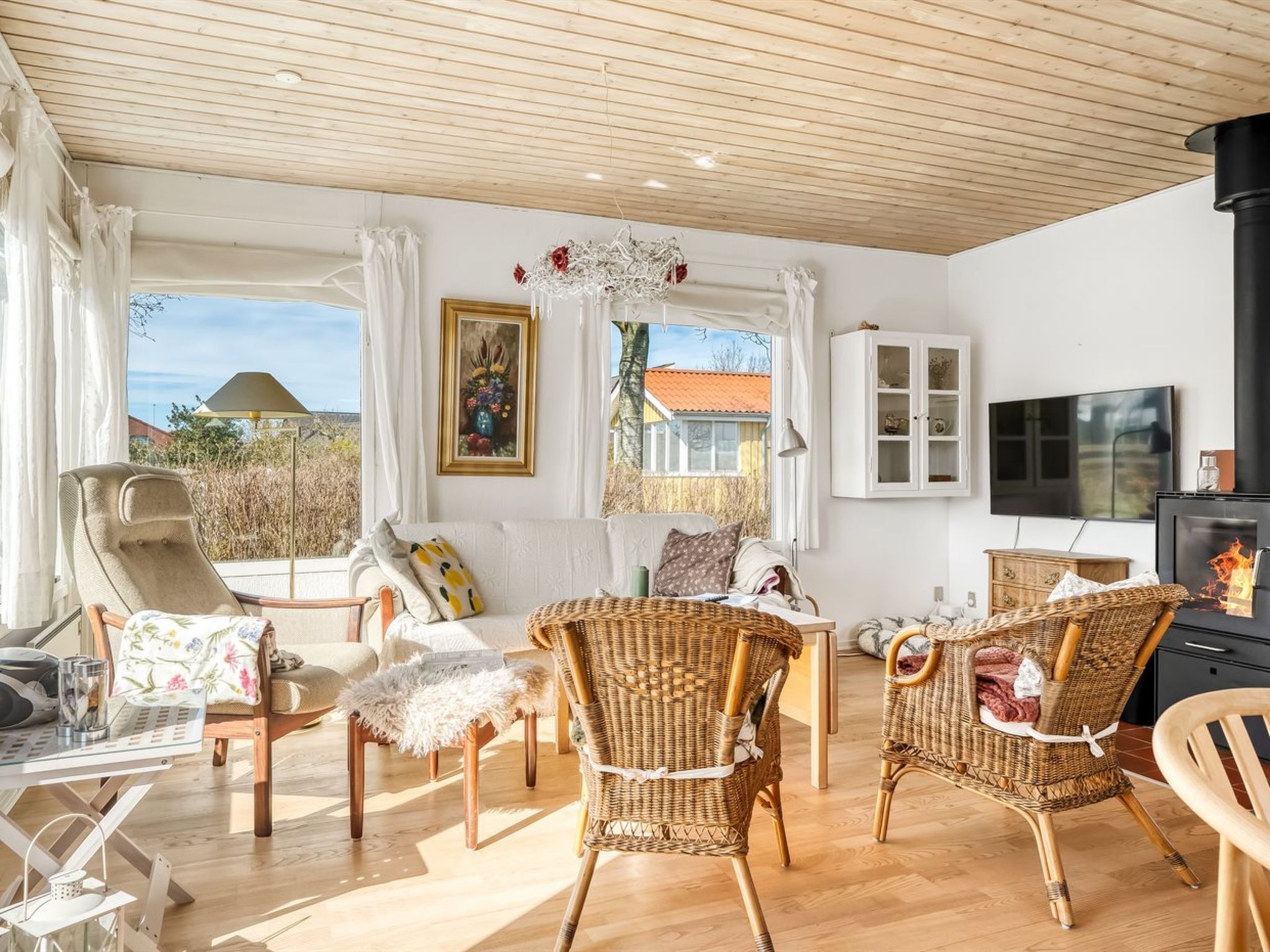 Een gezellige woonkamer met rieten meubels, een open haard en een televisie.