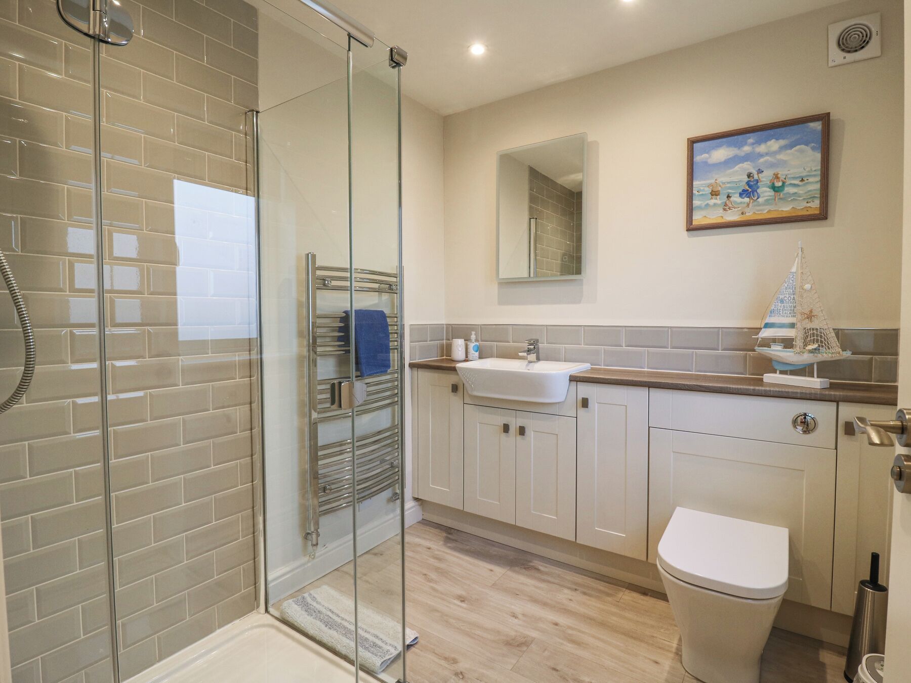 A modern bathroom with a glass shower enclosure, a sink, and a toilet.
