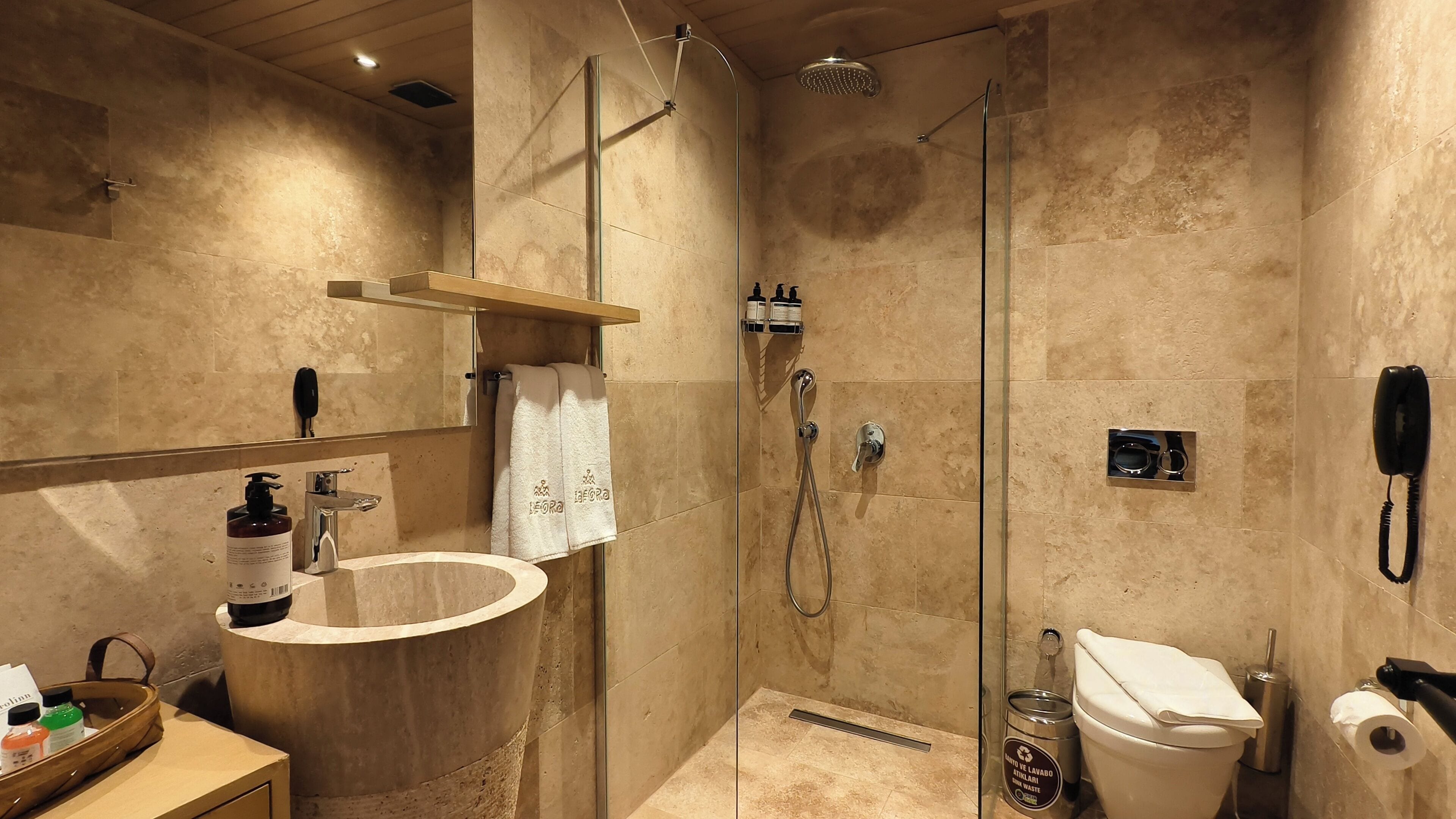 Een moderne badkamer met een douchecabine, een wastafelmeubel met een wastafel en een toilet.