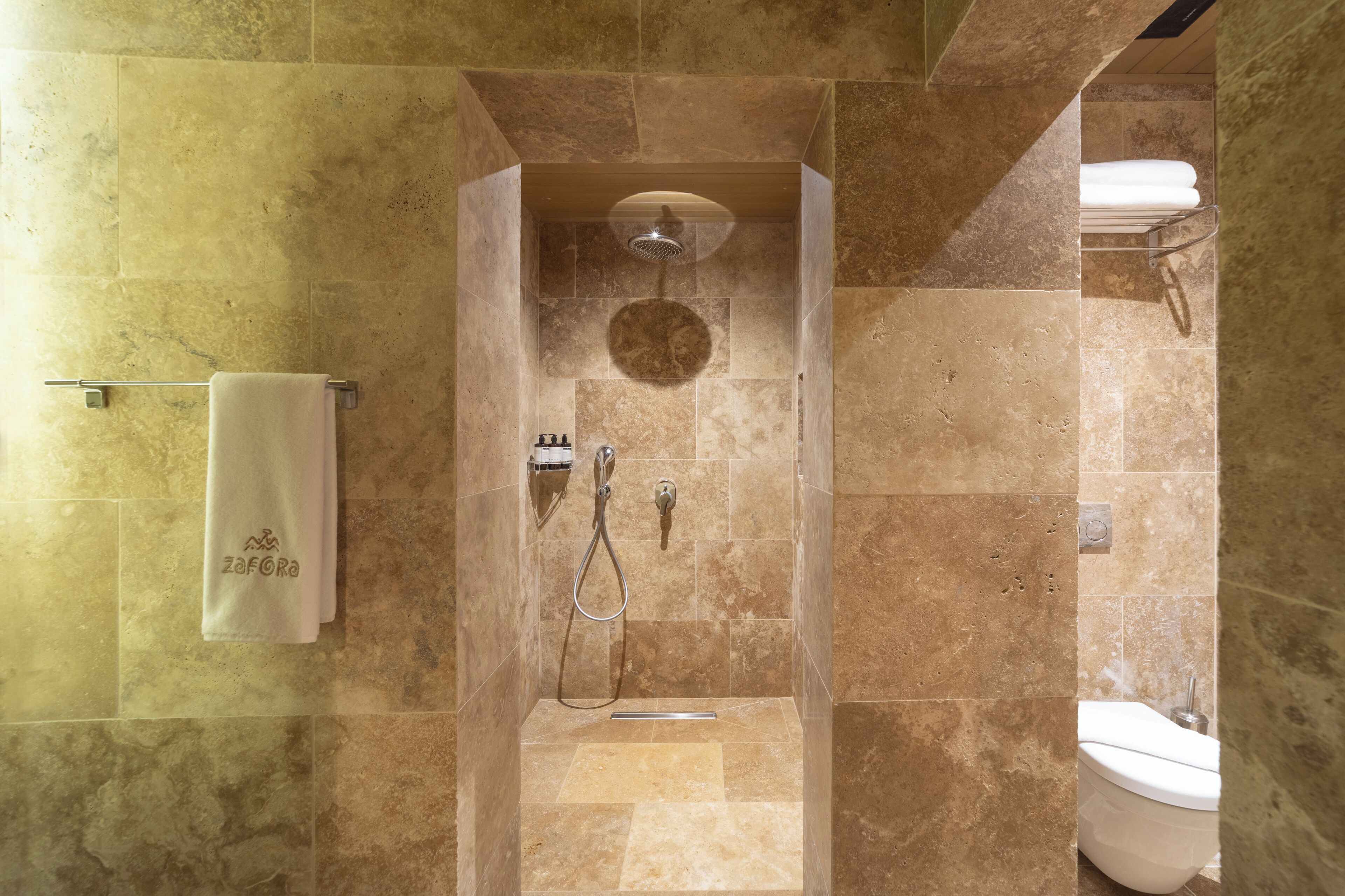 Un baño con ducha, inodoro y un perchero para toallas.