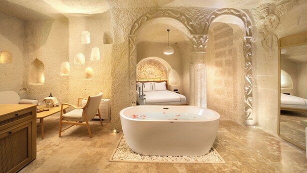 Un bagno di lusso con una vasca freestanding, un mobile vanitario in legno e un’area salotto.