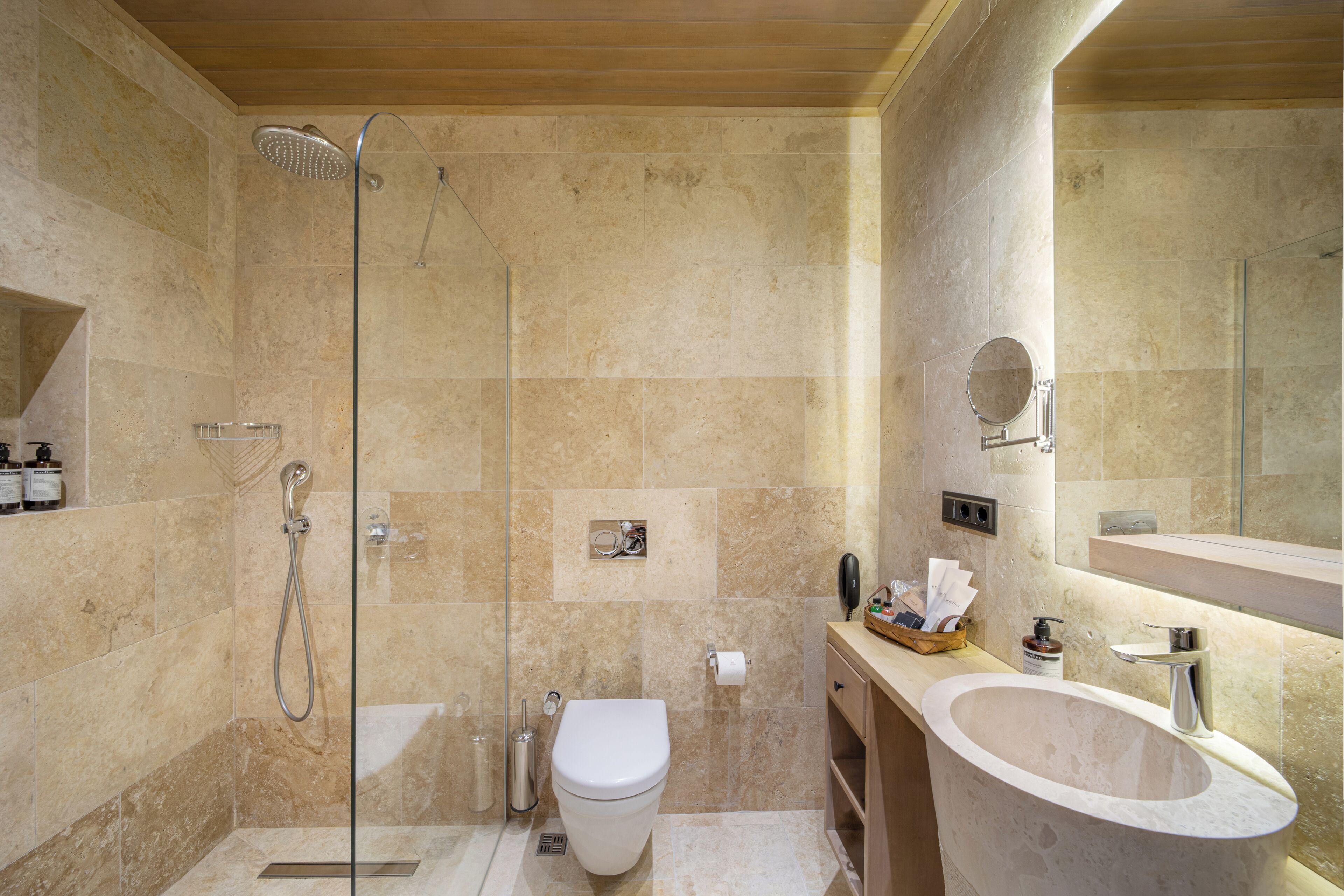 Un baño moderno con cabina de ducha de vidrio, inodoro y lavamanos independiente.
