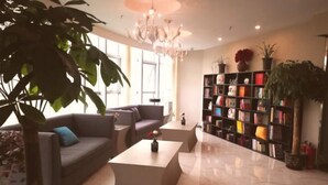 A modern living room with a sofa, coffee table, and a bookshelf. - Shanyehong Hotel (Beijing)