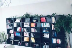 A bookshelf with various items and a plant.
