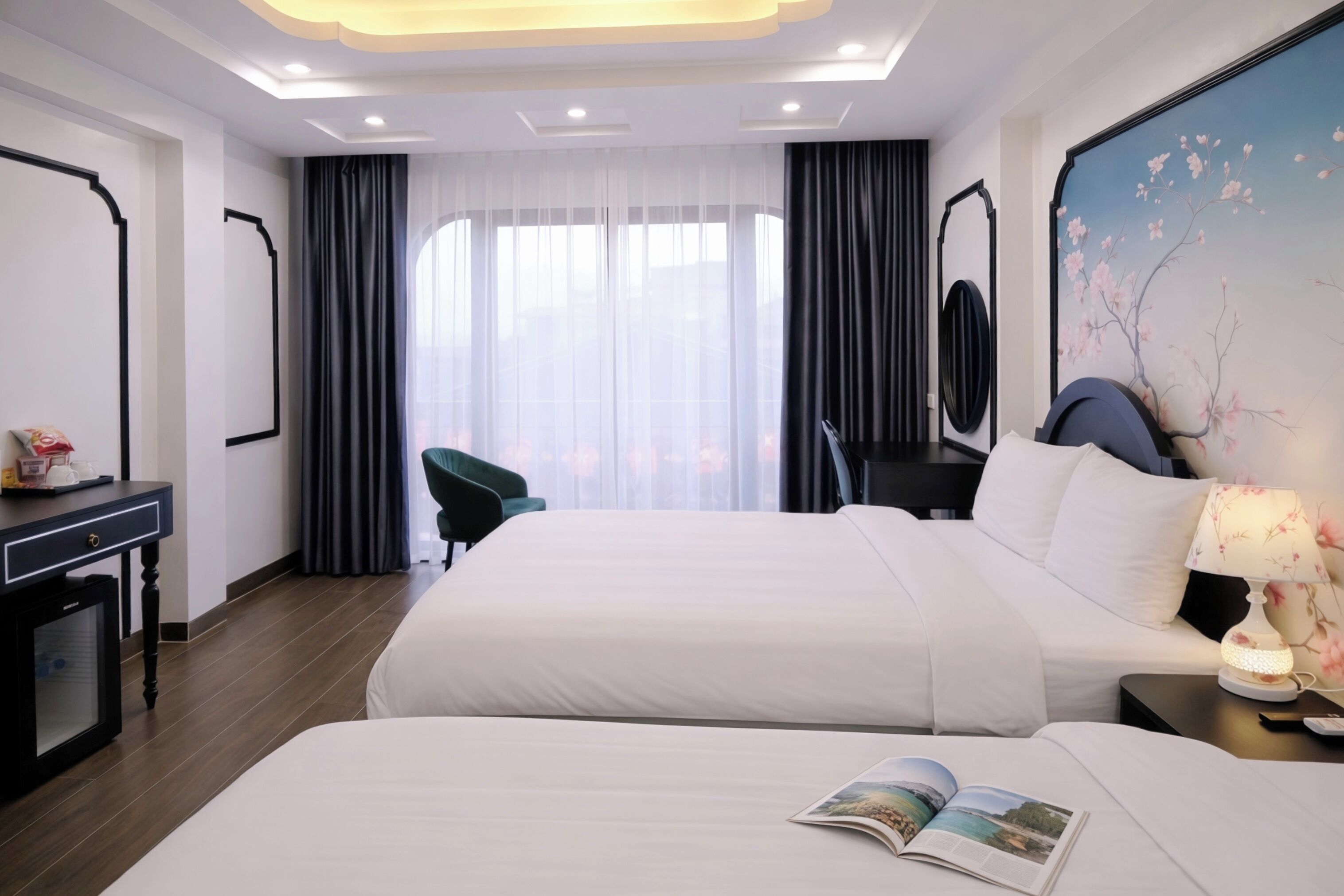Una habitación de hotel con dos camas, un escritorio, una silla, un televisor y un cuadro en la pared.