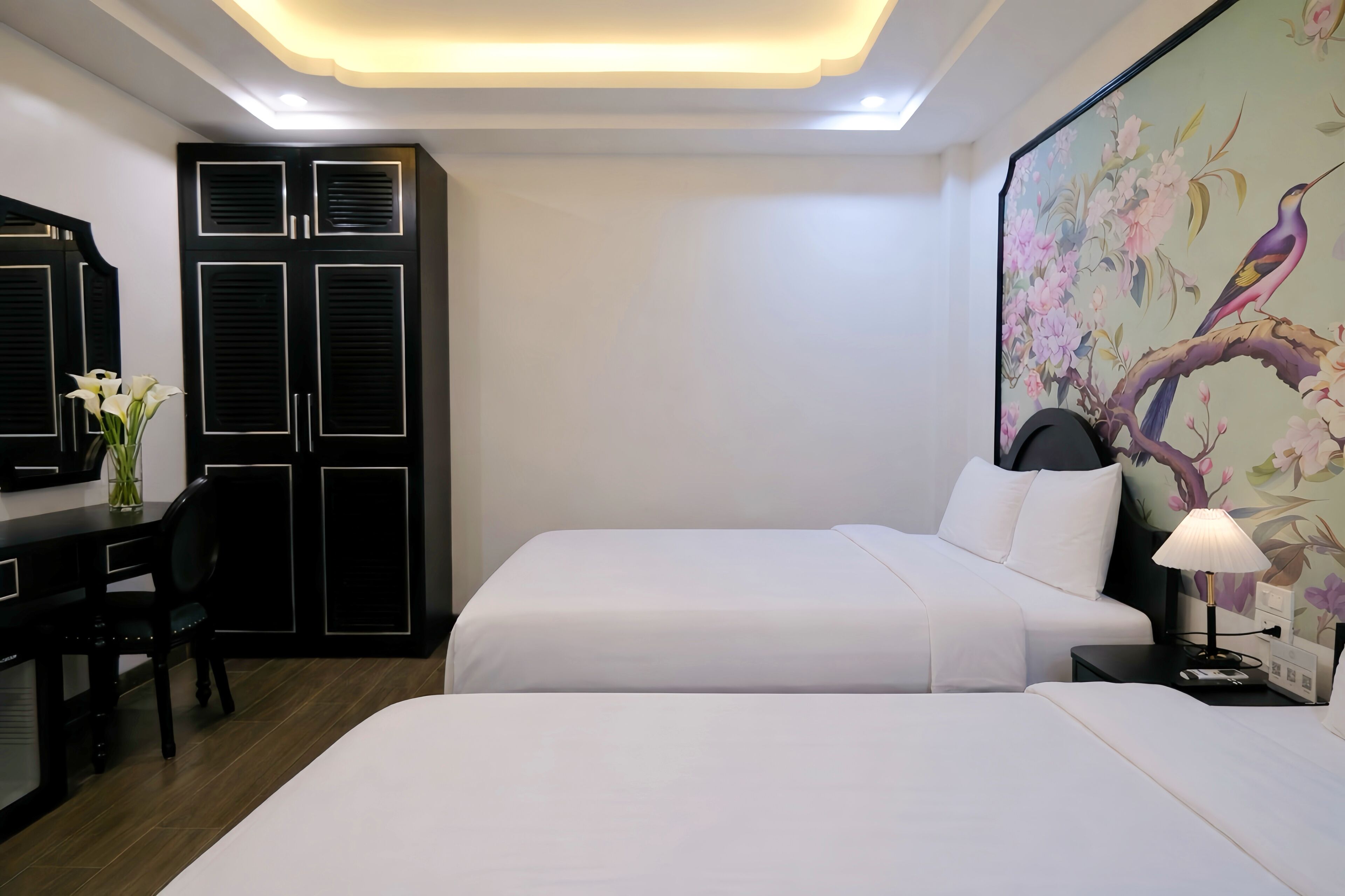 Una habitación de hotel con dos camas, un escritorio y un armario.