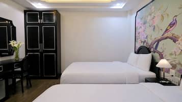 Una habitación de hotel con dos camas, un escritorio y un armario.