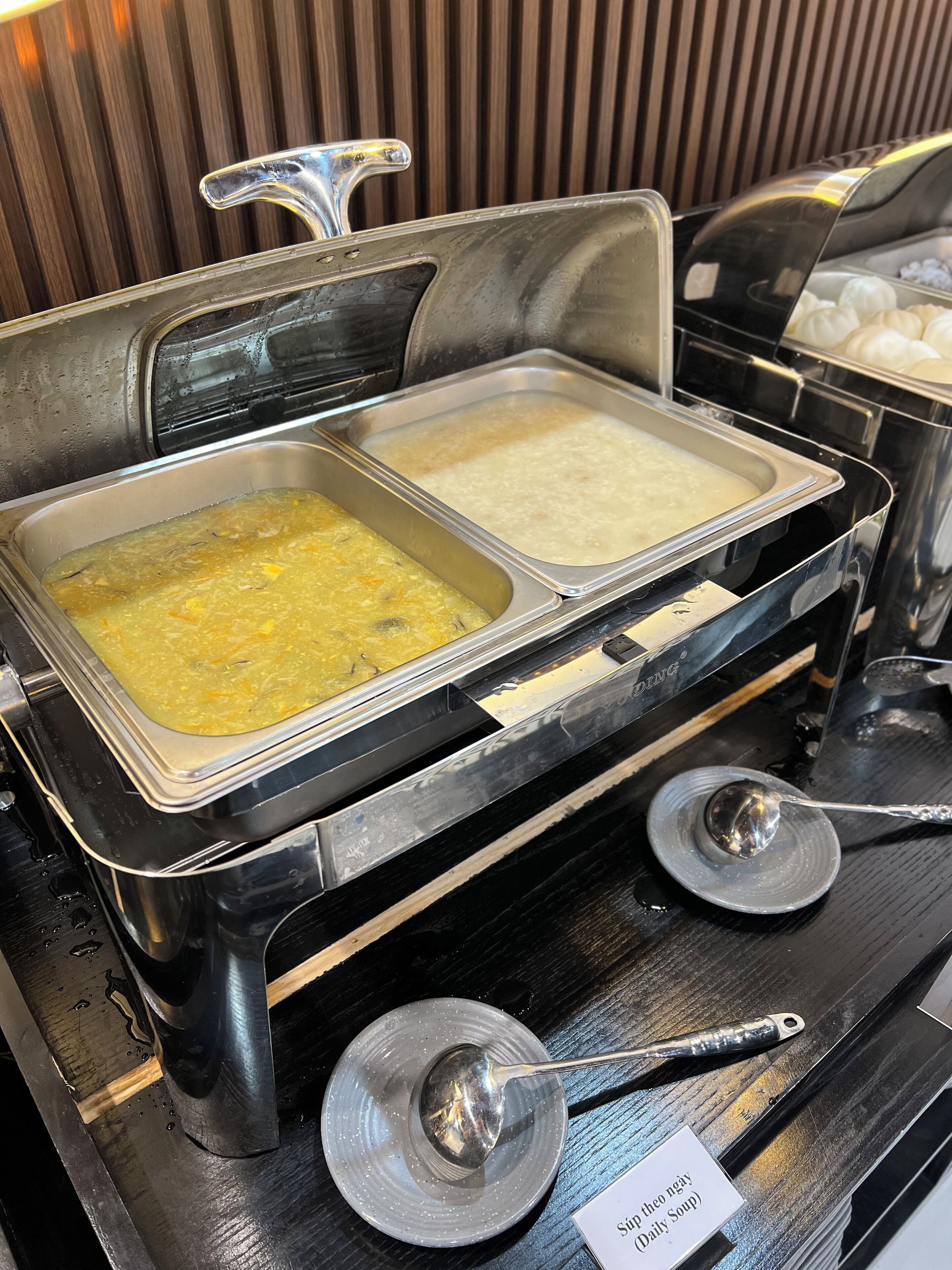 A buffet with three different dishes, each in a separate metal tray.