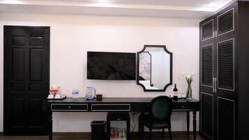 A modern room with a black desk, a large mirror, and a black wardrobe.