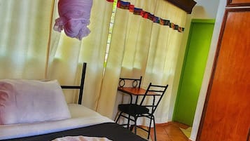A room with a bed, a table, and a chair.