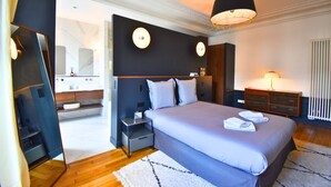 A modern bedroom with a large bed, bedside tables, a mirror, and a nightstand. - Paris Pantin Prestige (Pantin)