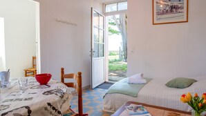 A cozy room with a bed, a table with a magazine, a red bowl, and a chair. - Rose-May by Interhome (La Bernerie-en Retz)