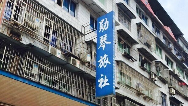 Un edificio de varios pisos con un letrero azul que indica un hotel.
