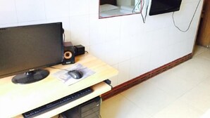 Un pequeño escritorio con una computadora, un ratón y un teclado.