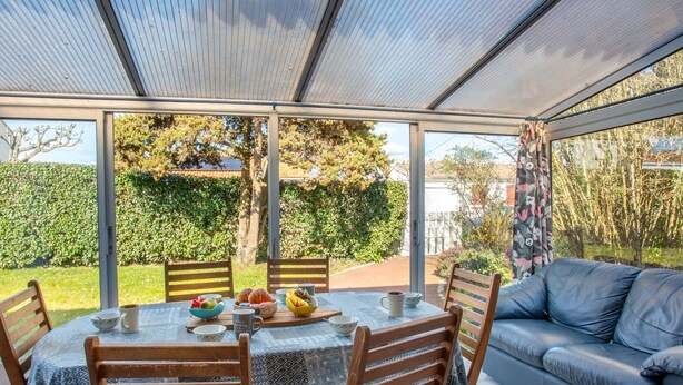 A covered patio with a table set for four, surrounded by wooden chairs. - La Bruyère by Interhome (La Bernerie-en Retz)