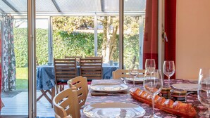 An outdoor dining area with a table set for two, featuring a baguette and wine glasses. - La Bruyère by Interhome (La Bernerie-en Retz)
