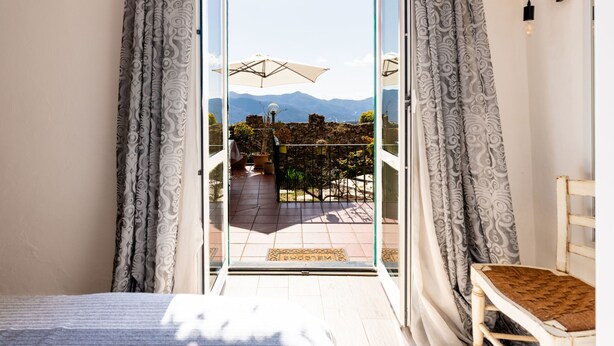 A bedroom with a sliding glass door leading to a balcony with a view of mountains. - Al Forte by Interhome (Arnasco)