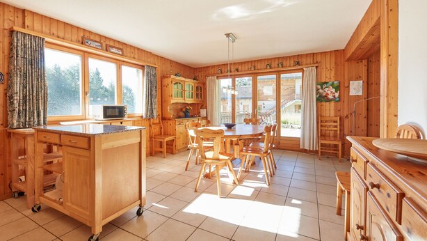 A wooden cabin with a kitchen, dining area, and large windows. - Grand Vue 01-02 by Interhome (Thyon-Les Collons)