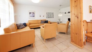 A modern living room with a sectional sofa, a wooden dining table, and a fireplace. - Grand Vue 01-02 by Interhome (Thyon-Les Collons)